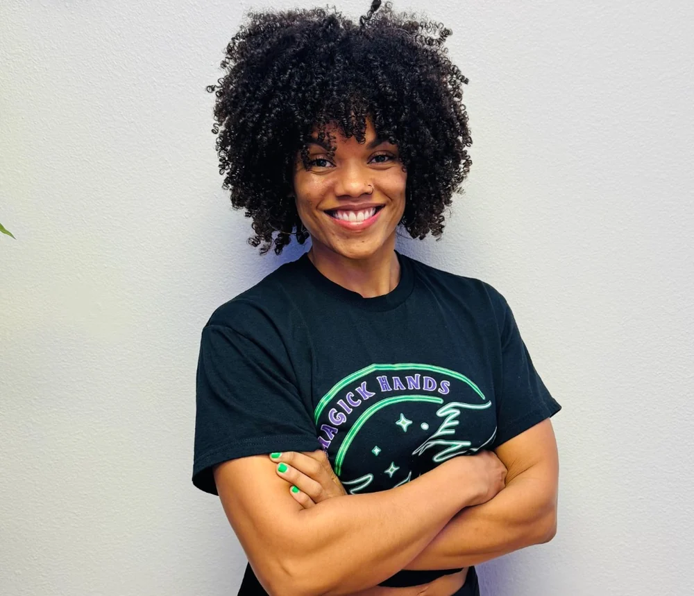 Abby McCall smiling in Magick Hands Bodyworks shirt